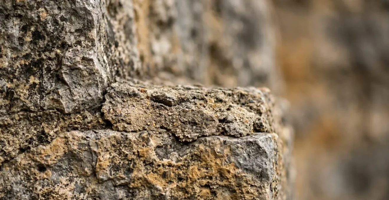 Gros plan de fissures sur un mur en pierre d'une maison ancienne